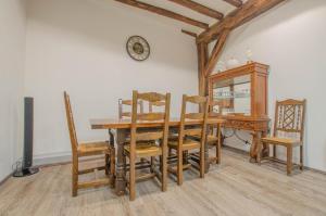 a dining room with a table and chairs and a clock at Chambre d'hote chez Angela in Bar-sur-Aube