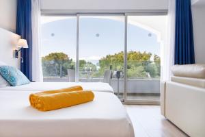 a hotel room with two beds and a large window at Mar Hotels Alcanada in Port d'Alcudia