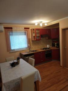 uma cozinha com armários vermelhos e uma mesa com cadeiras em Apartman Grbić em Vodnjan