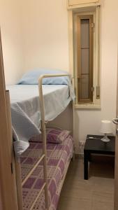 a small bedroom with a bunk bed with a mirror at Home Plutone in Giardini Naxos