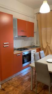 a kitchen with orange cabinets and a table with chairs at Home Plutone in Giardini Naxos