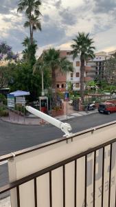 a white railing with palm trees and a building at Home Plutone in Giardini Naxos
