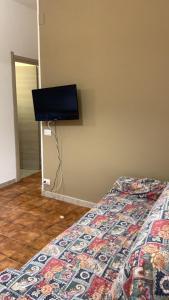 a bedroom with a bed with a tv on the wall at Home Plutone in Giardini Naxos