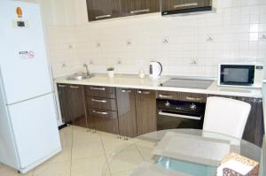 uma cozinha com um lavatório, um frigorífico e uma mesa em Апартаменты на Марсельской, Кадорр, 4я Жемчужина em Odessa