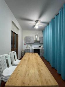 einen langen Holztisch in einem Zimmer mit blauen Vorhängen in der Unterkunft Mare & Montagna in Capitana