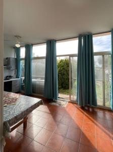 a bedroom with green curtains and a large window at Mare & Montagna in Capitana