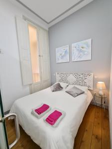 ein Schlafzimmer mit einem weißen Bett mit zwei Handtüchern darauf in der Unterkunft AsAtHome Arenal Apartment in Madrid