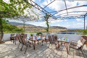 a patio with tables and chairs and a view at Apostolos Rooms in Líndos