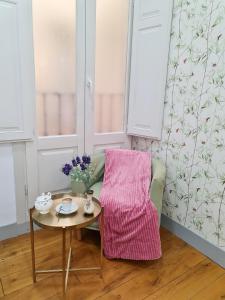 einen Tisch und einen Stuhl mit einer rosa Decke in der Unterkunft AsAtHome Arenal Apartment in Madrid