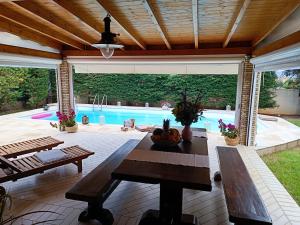 Celestial Azure Villa, your Athenian Country House Retreat في مركوبوولو: فناء مع طاولة ومسبح