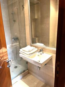 bagno con lavandino, doccia e specchio di Short Stay Apartment aéroport casablanca a Nouaseur