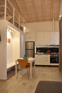 a kitchen with a table and a kitchen with white cabinets at The art studio in Samothráki