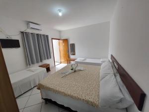 um quarto com duas camas e um bicho de peluche na cama em Hotel Kalifornia em Porto Seguro