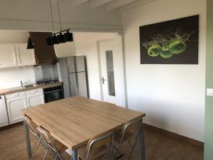 a kitchen with a wooden table and a picture of fruit on the wall at Le 21 in Écuires