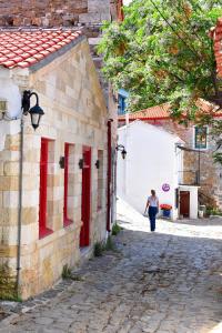 Eine Frau, die eine Straße entlang geht, neben einem Gebäude in der Unterkunft The art studio in Samothráki