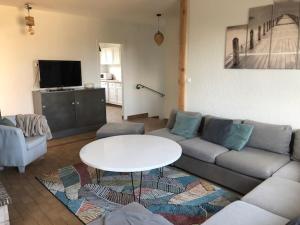 a living room with a couch and a table at Le 21 in Écuires