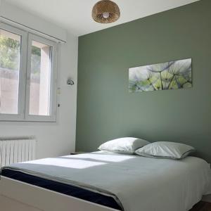 a white bedroom with a bed and a window at Le 21 in Écuires