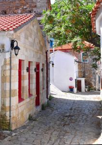 an alley with red doors and a brick building at The art studio in Samothráki