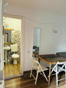 a room with a table and a toilet and a mirror at Zen Hostel in Cluj-Napoca