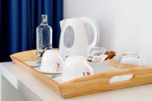 a wooden tray with cups and a bottle on a table at Mar Hotels Alcanada in Port d'Alcudia