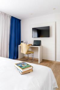 a bedroom with a bed with a desk and a chair at Mar Hotels Alcanada in Port d'Alcudia