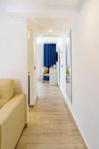 a corridor of a room with a couch and a mirror at Mar Hotels Alcanada in Port d'Alcudia