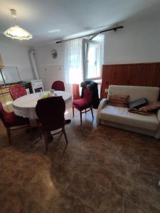 ein Wohnzimmer mit einem Sofa, einem Tisch und Stühlen in der Unterkunft HeliVilla budget house in Rijeka
