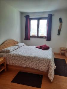 - une chambre avec un lit et une fenêtre dans l'établissement La Casetta di Mariangela, à Camporosso in Valcanale