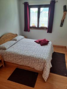 a bedroom with a bed and a window at La Casetta di Mariangela in Camporosso in Valcanale