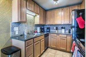 a kitchen with wooden cabinets and a sink and a refrigerator at Ocean View, 2 Baths, 2 Bedrooms, No Stairs, Best Area, WD, Jacuzzi Bath, Balcony, View, 925sf in Tacoma