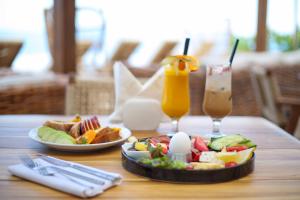 a table with two plates of food and two glasses of juice at Regina Blu in Vlorë