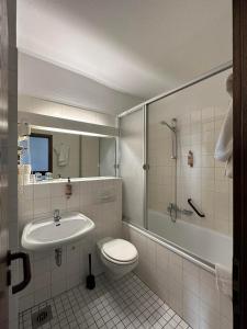 a bathroom with a toilet and a sink and a shower at Hotel Astor in Wuppertal