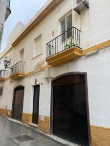 a building with a garage and a balcony at Casa de Santa María in El Puerto de Santa María
