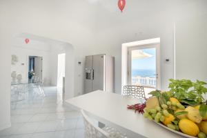 a white kitchen with a bowl of fruit on a counter at Villa Tesoro in Positano