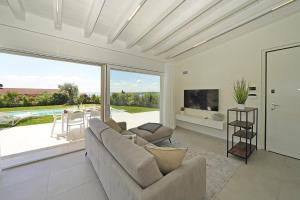 a living room with a couch and a large window at Villa Ester by Wonderful Italy in Moniga