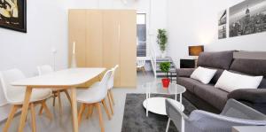 a living room with a couch and a table and chairs at My City Home - Acogedor estudio en Ciudad Lineal in Madrid