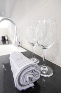 two wine glasses and a towel on a counter at סוויטה אגריפס 8 in Jerusalem