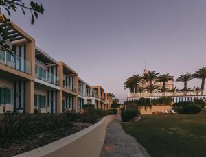 a walkway next to a row of apartment buildings at Bela Vista Hotel & Spa - Relais & Chateaux in Portimão