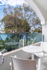 a white table and chairs in front of a large window at Mar Hotels Alcanada in Port d'Alcudia