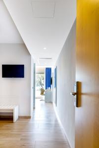 a hallway of a house with white walls and wooden floors at Mar Hotels Alcanada in Port d'Alcudia