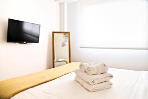 una pila de toallas sentadas encima de una cama en Garage incluido! Buenos Aires - Villa Urquiza en Buenos Aires