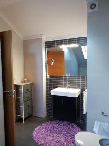 łazienka z umywalką i fioletowym dywanem w obiekcie Maravilloso Ático-duplex w mieście Vigo +14 zdjęć