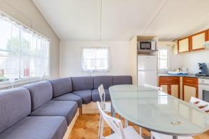 a living room with a blue couch and a table at Mobil Home Le Tokyo in Noyelles-sur-Mer