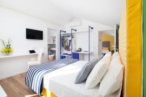 um quarto com uma cama branca com almofadas azuis e brancas em YourHome - Relais Loggia Li Galli em Massa Lubrense