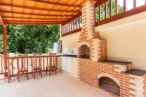 un patio al aire libre con una chimenea de ladrillo y sillas en Casa Maha en Niterói