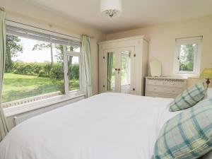 1 dormitorio con cama y ventana grande en Lavender Lodge, en Haverfordwest