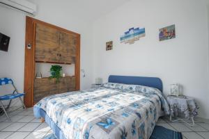 Schlafzimmer mit einem Bett mit blauer Decke in der Unterkunft Angela Appartament in Lipari