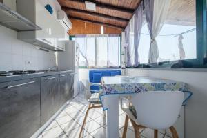 eine Küche mit einer Theke, einem Tisch und Stühlen in der Unterkunft Angela Appartament in Lipari