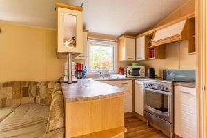 małą kuchnię z drewnianymi szafkami i blatem w obiekcie Mobilehome au bord de l'eau w mieście Gastes