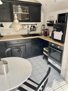 una cocina con armarios negros y una mesa con sillas en Maison Beaumont, en Springe